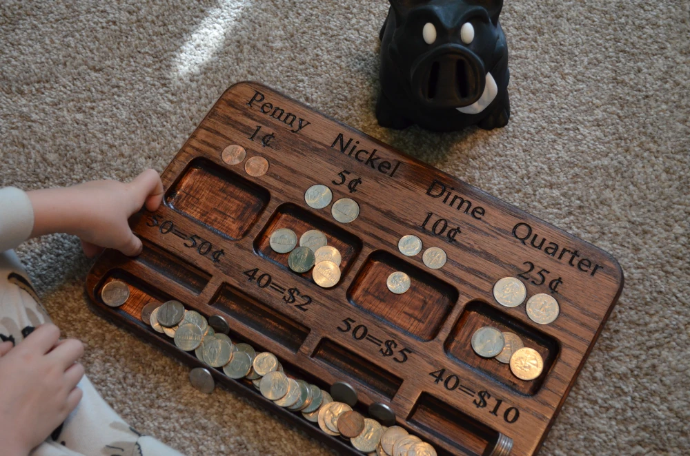 a wooden board with coins and a piggy bank